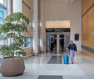 A person walking down a hallway with luggage